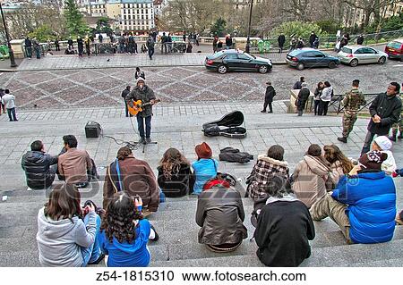 Stock Image - People listenig at street musician in Montmartre, Basilique du Sacre Coeur, Paris, France. Fotosearch
