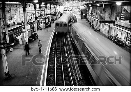 Stock Photograph - People on a platform of a train station. London, England. Fotosearch