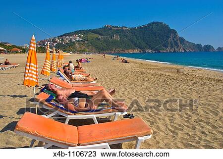 Stock Image - People on beach in Alanya Mediterranian coast Anatolia region Turkey Asia. Fotosearch