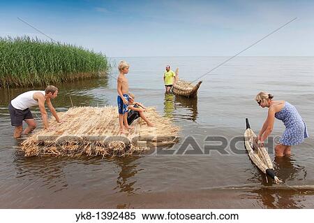 Stock Photography - People on Reed Boat and Reed Mat, Lake Peipsi, Estonia, Europe. Fotosearch
