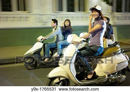 People on the streets of Vietnam at night on scooters View Large Photo Image Stock Image - People on the streets of Vietnam at night on scooters. Fotosearch