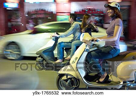 People on the streets of Vietnam at night on scooters View Large Photo Image Stock Image - People on the streets of Vietnam at night on scooters. Fotosearch