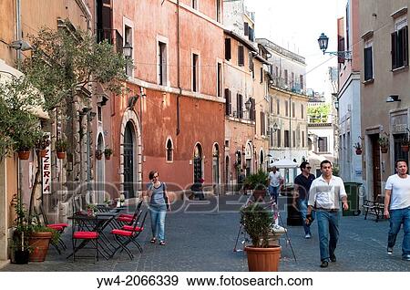 Stock Photo - People passing by the 15th century Palazzo Fucci and a cafe in a quiet cobbled street, Via Palatina, in the town centre, Tivoli, Lazio, Italy.. Fotosearch