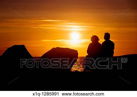 People sitting and enjoying the midnight sun setting over the Atlantic Ocean Reykjavik Iceland View Large Photo Image Stock Image - People sitting and enjoying the midnight sun setting over the Atlantic Ocean Reykjavik Iceland. Fotosearch