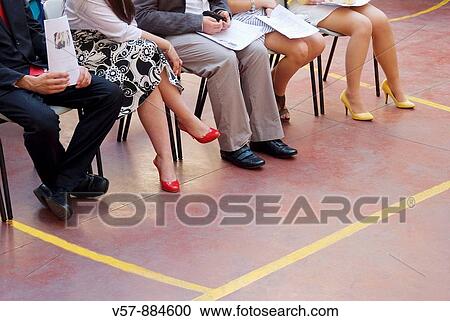 Stock Image - People sitting, detail of their legs. Fotosearch