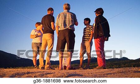 People talking near open flame of natural gas burning vent from the ground near Portico de Romagna, Emilia-Romagna, Italy. View Large Photo Image Stock Photo - People talking near open flame of natural gas burning vent from the ground near Portico de Romagna, Emilia-Romagna, Italy.. Fotosearch