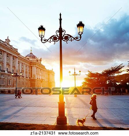 Stock Image - People walking along the Royal Palace of Madrid. Spain.. Fotosearch