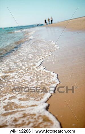 Stock Image - People walking on the beach. Le Moulleau. Arcachon. Gironde. France.. Fotosearch