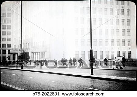 Stock Image - People walking on the way to work in London Bridge, City of London, England. Fotosearch