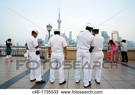 Stock Image - People watching Pudong skyline and Pearl tower from the Bund, Shanghai, China.. Fotosearch