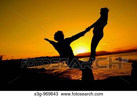 Stock Image - Performers practice their dance routines at the beach during sunset in Byron Bay. New South Wales, Australia. Fotosearch