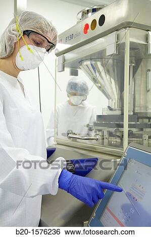 Stock Photograph - Performing technical checks during a compression process, Tableting, Clean room, Pharmaceutical plant, Drug manufacturing plant, Research Center, Pharmacy, Area Health, Tecnalia Research & Innovation, Araba Technology Park, Miano, Basque Country, Spain. Fotosearch