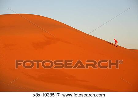 Person climbing a dune in Erg Chebbi, Merzouga, Morocco View Large Photo Image Stock Photo - Person climbing a dune in Erg Chebbi, Merzouga, Morocco. Fotosearch