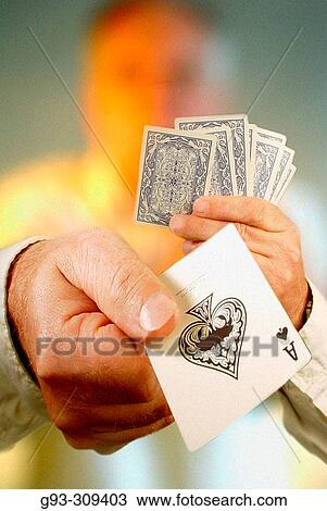 Stock Image - Person holding deck of cards showing ace of spades. Fotosearch
