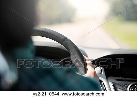 Person on a journey, driving a car. Holding the steering wheel and looking at an empty road. View Large Photo Image Picture - Person on a journey, driving a car. Holding the steering wheel and looking at an empty road.. Fotosearch