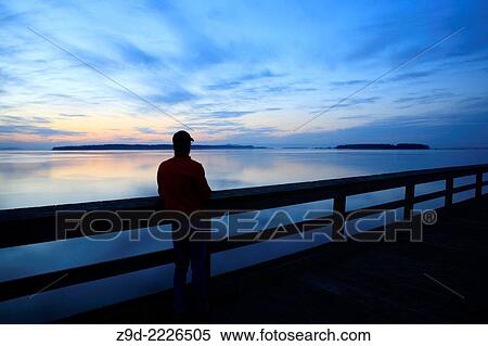 Person on fishing pier at dawn, Sidney, British Columbia. View Large Photo Image Stock Photography - Person on fishing pier at dawn, Sidney, British Columbia.. Fotosearch