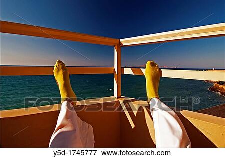 person resting on terrace, sitting with legs up, sea and sky view in the background, symbol of leisure, Heraklion, Crete, Greek Islands, Europe View Large Photo Image Stock Photo - person resting on terrace, sitting with legs up, sea and sky view in the background, symbol of leisure, Heraklion, Crete, Greek Islands, Europe. Fotosearch
