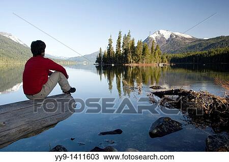 Stock Image - Person sitting by Lake Wenatchee - Lake Wenatchee State Park, Washington. Fotosearch