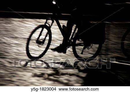 person walking on wet cobbles in street road at night View Large Photo Image Picture - person walking on wet cobbles in street road at night. Fotosearch