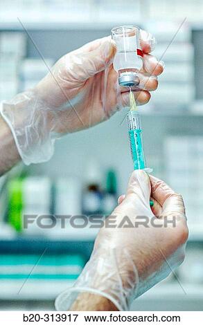 Person with gloves preparing medicine at chemist of hospital View Large Photo Image Stock Photo - Person with gloves preparing medicine at chemist of hospital. Fotosearch