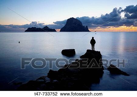 Stock Image - Persona en Cala d? Hort al atardecer. Ibiza, Baleares, Espaa.. Fotosearch