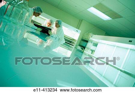 Pharmaceutical lab researchers working in clean room View Large Photo Image Picture - Pharmaceutical lab researchers working in clean room. Fotosearch