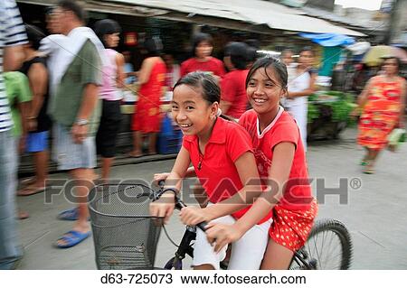 PHILIPPINES Girls on bicycle Scene in a street market at Bagong Silangan, Quezon City, Manila View Large Photo Image Stock Image - PHILIPPINES Girls on bicycle Scene in a street market at Bagong Silangan, Quezon City, Manila. Fotosearch