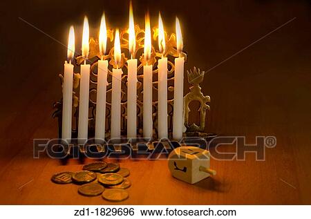 Photo of a dreidel spinning top, gelts candy coins and an ancient brass menorah for the Jewish holiday of Hanukkah View Large Photo Image Stock Photograph - Photo of a dreidel spinning top, gelts candy coins and an ancient brass menorah for the Jewish holiday of Hanukkah. Fotosearch