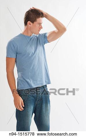 Stock Photo - Photo of American plans for a teenage boy standing with hand in hair.. Fotosearch