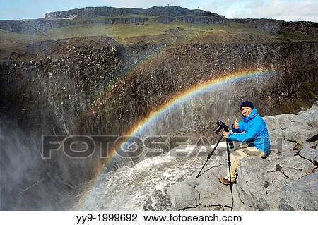 Photographer and Rainbow at Dettifoss Waterfall in Vatnajokull National Park, Northeast Iceland. View Large Photo Image Stock Image - Photographer and Rainbow at Dettifoss Waterfall in Vatnajokull National Park, Northeast Iceland.. Fotosearch