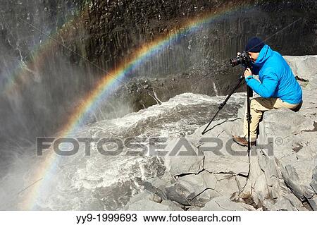 Photographer and Rainbow at Dettifoss Waterfall in Vatnajokull National Park, Northeast Iceland. View Large Photo Image Stock Image - Photographer and Rainbow at Dettifoss Waterfall in Vatnajokull National Park, Northeast Iceland.. Fotosearch