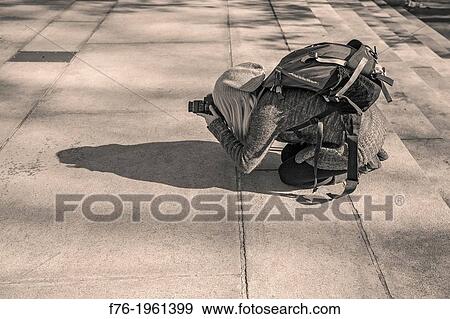 Stock Photo - Photographer down on ground level photographing from a low angle or vantage point.. Fotosearch