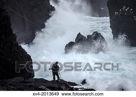 Photographer taking pictures at Reykjanesta cliffs, Southern Iceland. View Large Photo Image Stock Photo - Photographer taking pictures at Reykjanesta cliffs, Southern Iceland.. Fotosearch