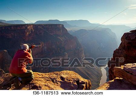 Photographer taking pictures next to edge of canyon cliff above the Colorado River, Toroweap, Grand Canyon National Park, Arizona View Large Photo Image Stock Image - Photographer taking pictures next to edge of canyon cliff above the Colorado River, Toroweap, Grand Canyon National Park, Arizona. Fotosearch