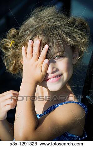 Picture of a young girl covering one eye with her hand View Large Photo Image Stock Photo - Picture of a young girl covering one eye with her hand. Fotosearch