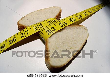 Piece of bread measuring waistline View Large Photo Image Stock Photograph - Piece of bread measuring waistline. Fotosearch