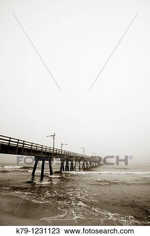 Pier at the beach on a cloudy day. View Large Photo Image Stock Image - Pier at the beach on a cloudy day.. Fotosearch