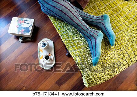 Stock Image - piernas de mujer descalza, relajada en una chaise longue, female legs barefoot, relaxed on a chaise longue,. Fotosearch