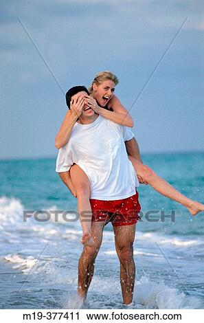 piggy back ride on the beach View Large Photo Image Stock Image - piggy back ride on the beach. Fotosearch