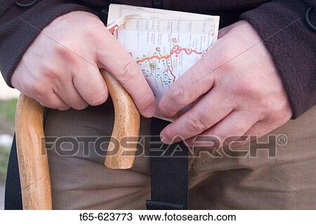 Stock Image - Pilgrim with map and cane. Road to Santiago near Triacastela, Lugo province. Spain. Fotosearch