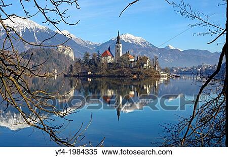 Stock Photography - Pilgrimage Church of the Assumption of Mary on Bled Island and Bled Castle Lake Bled Slovenia.. Fotosearch