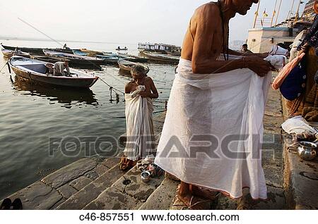 Stock Image - Pilgrims on the ghats by the Ganges river, Varanasi. Uttar Pradesh, India. Fotosearch