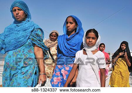 Stock Photo - Pilgrims walking around Golden Temple by the holly lake, Punjab Amritsar India. Fotosearch