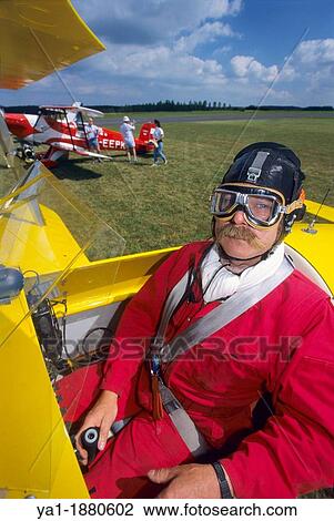 Stock Image - Pilot in cockpit of ultra light biplane Kiebitz, France. Fotosearch