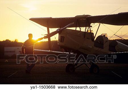 Pilot near an old trainer biplane De Havilland DH 82a Tiger Moth on sunset View Large Photo Image Stock Photo - Pilot near an old trainer biplane De Havilland DH 82a Tiger Moth on sunset. Fotosearch