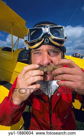 Pilot of ultra light biplane Kiebitz arranging his mustache after a flight, France View Large Photo Image Picture - Pilot of ultra light biplane Kiebitz arranging his mustache after a flight, France. Fotosearch