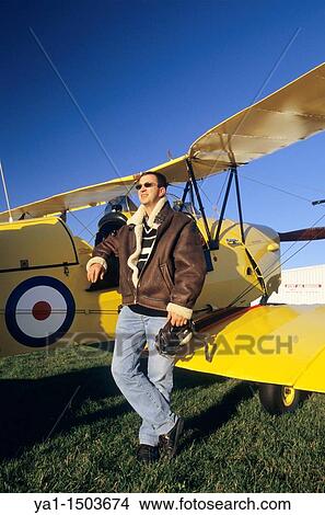 Pilot with flying jacket near old British trainer biplane De Havilland DH 82a Tiger Moth View Large Photo Image Picture - Pilot with flying jacket near old British trainer biplane De Havilland DH 82a Tiger Moth. Fotosearch