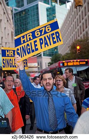 Stock Photograph - Pittsburgh, Pennsylvania - Health care activists march through the streets during the 2009 AFL-CIO convention on their way to viewing Michael Moore's new film: Capitalism: A Love Story. Fotosearch
