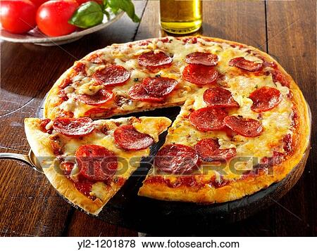 Stock Photo - Pizza topped with pepperoni & cheese with a slice out. Fotosearch