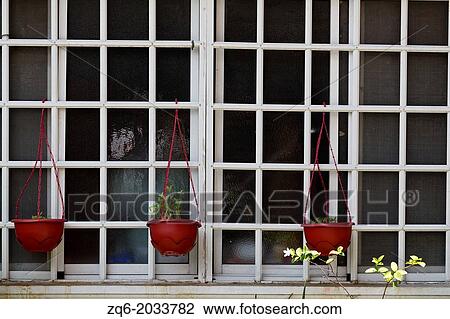 Stock Image - Plant Pots in a Window in Manila, Philippines.. Fotosearch